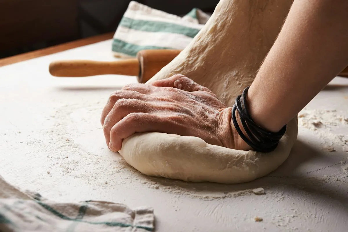 Pizza dough being stretched by hand
