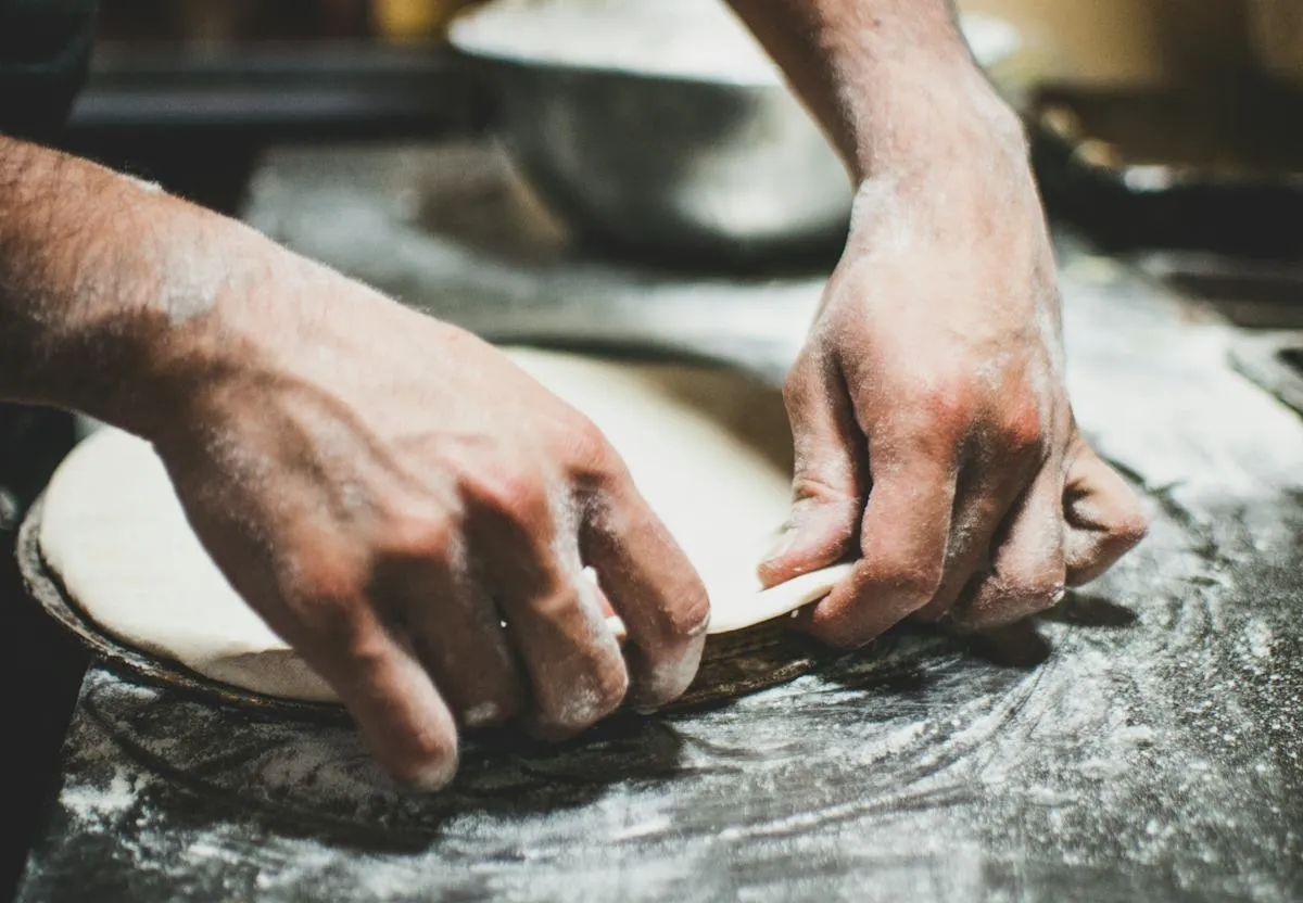 Hands preparing pizza dough
