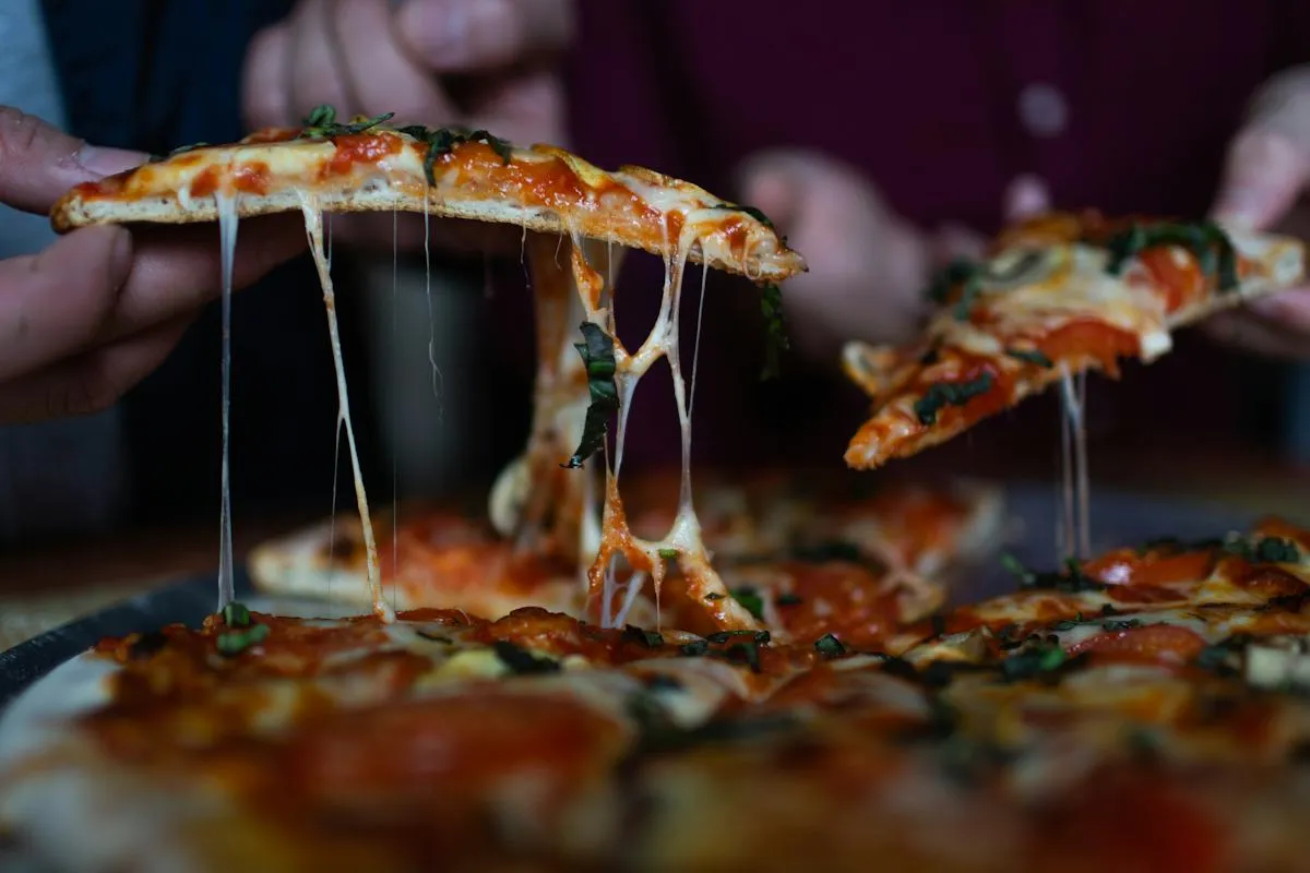 Warm melted cheese stretching from a pizza slice