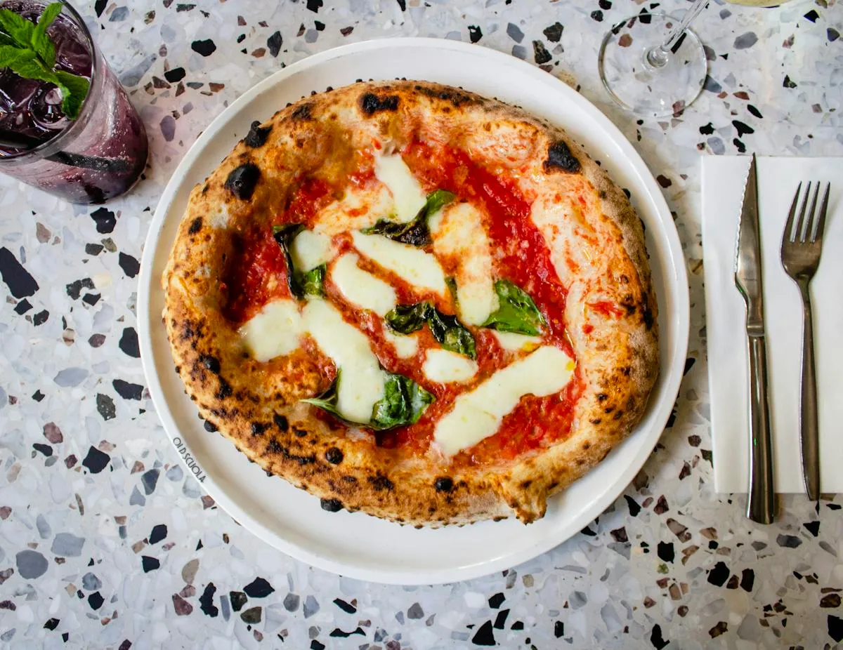 Round Italian pizza with basil leaves