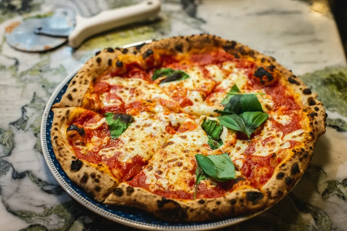 Pizza topped with tomatoes, cheese and fresh basil