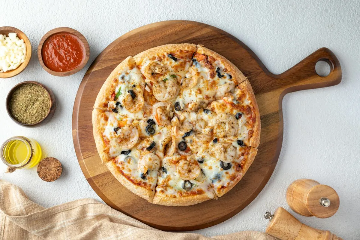 Pizza served on a wooden board with dipping sauces