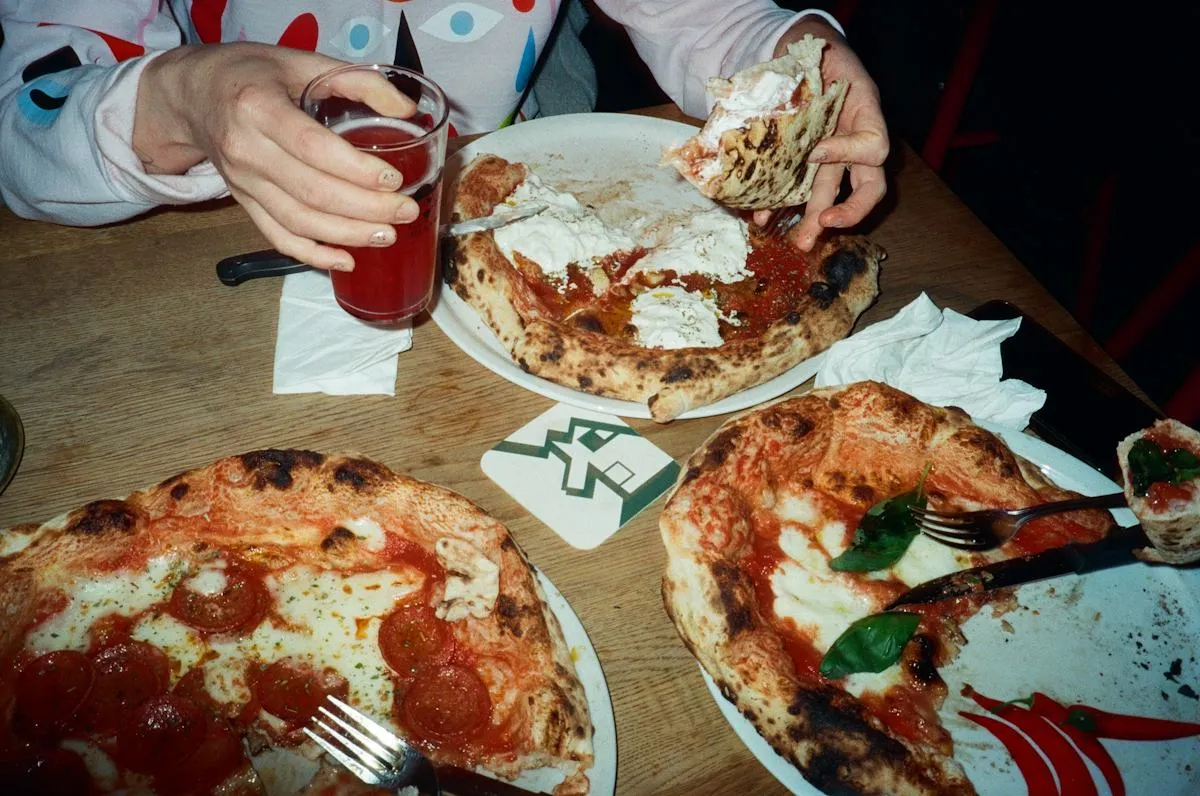 Diners enjoying slices of pizza together
